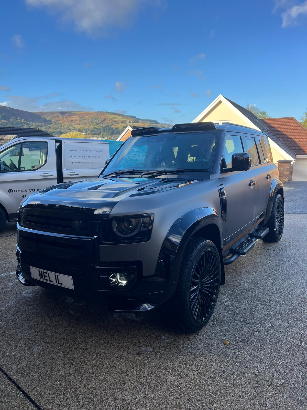 Silver Land Rover Defender freshly deep-cleaned alongside The Auto Spa mobile detailing van on a South Wales driveway